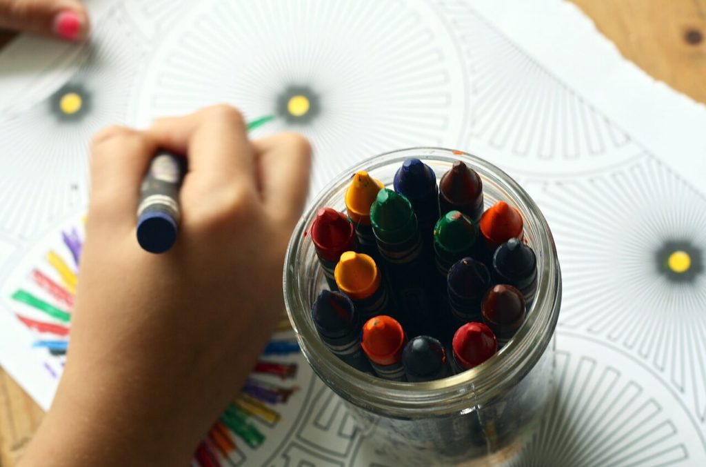 pre-school child coloring with crayons